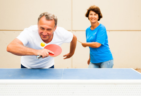 mature couple playing ping pong outdoors at outdoorの写真素材
