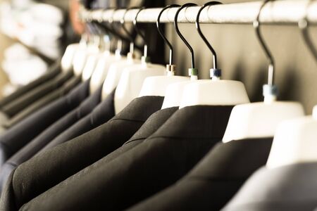 row of jackets on hangers in men clothing storeの写真素材