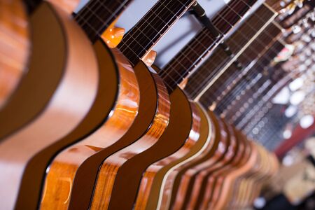 long line of new acoustic guitars in music storeの写真素材