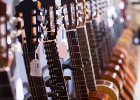 row of new nec of acoustic guitars in music shopの写真素材