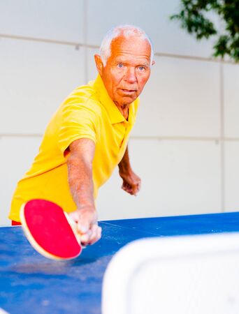 portrait of elderly man with rackets for table tennisの写真素材