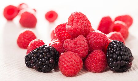 fresh raspberry and blackberry berries on white backgroundの写真素材