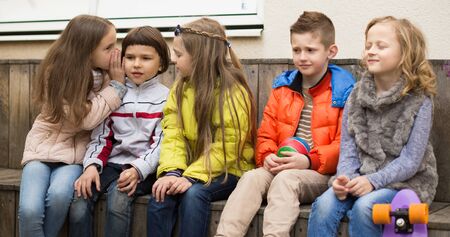 european Children on a bench playing Chinese whispersの写真素材