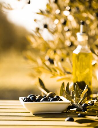 still life with green and black olives on table in olive groveの写真素材