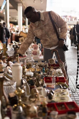 Afro-American guy considers things sacond hands on flea marketの写真素材