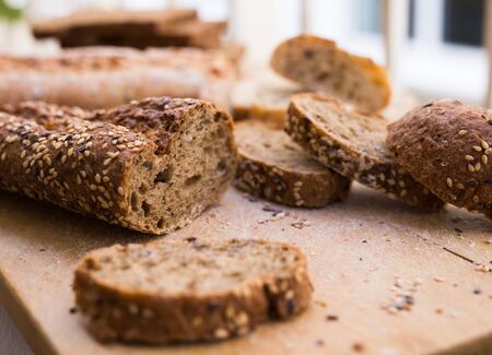 slices of fresh loaf of bread on wooden boardの写真素材