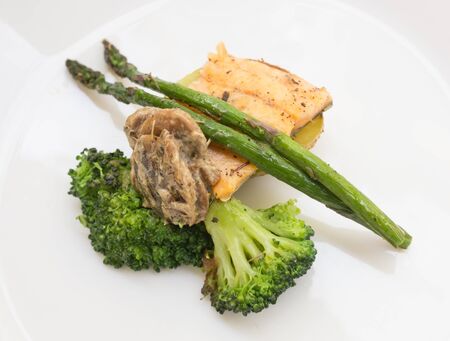 delicious dish of fried river trout fillet with a complex side dish of broccoli, asparagus sprouts...