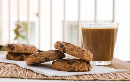 breakfast of cookies with chocolate and hazelnuts and coffee with milk lie on the table