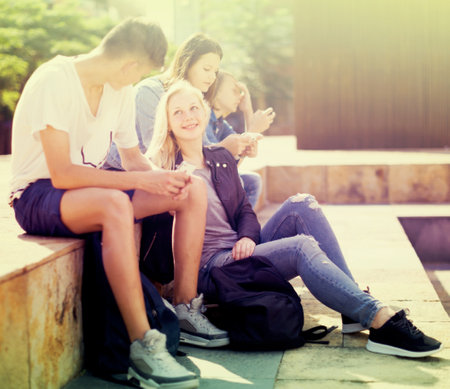group of teenagers communicate in schoolyardの写真素材