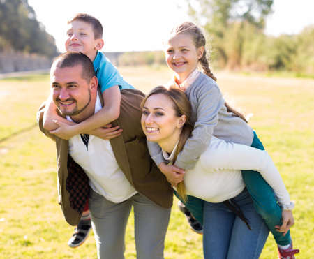 happy family with two children boy and girl walking outdoorの写真素材