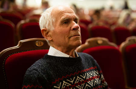 Elderly man watching a play in theaterの写真素材