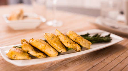 fried chicken breast pieces with asparagus on white plate
