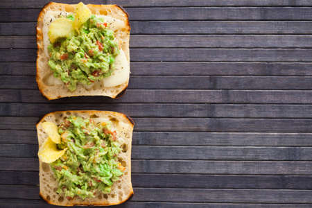 morning toast with melted cheese and guacamole. top view