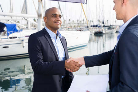 two male businessmen agree on a deal at the seaportの写真素材