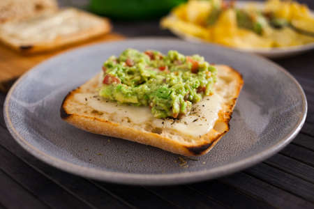 healthy breakfast. toasted italian ciabatta bread with melted cheese and avocado puree