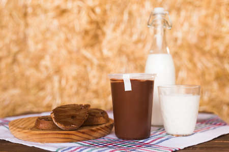 breakfast of milk and wheat bread with nut butter on the table in the hayloftの写真素材