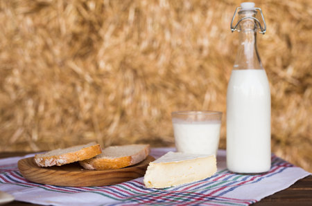 Rustic breakfast of milk, fresh wheat bread and brie in the hayloftの写真素材