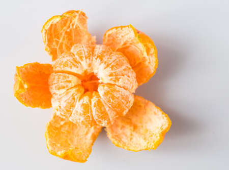 fresh mandarin with peeled peel on white backgroundの写真素材