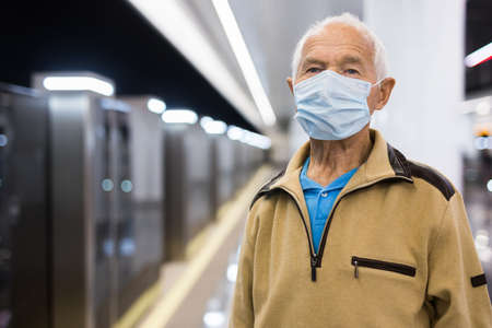 European old man standing in subway station and waiting for train.の写真素材