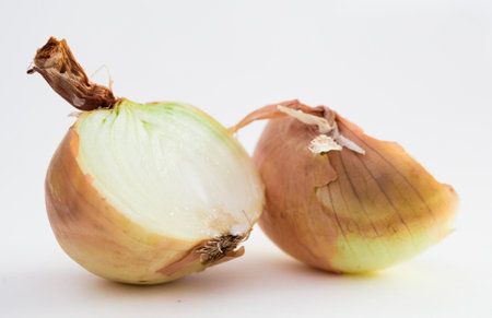 two halves of ripe onions on black stone boardの写真素材