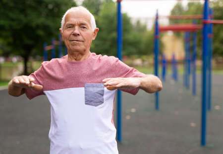 Fitness, sport and healthy lifestyle concept - happy senior woman exercising at summer parkの写真素材
