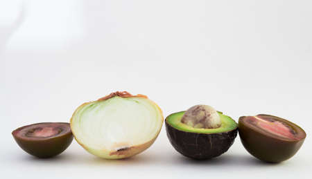 ripe vegetables black tomatoes, avocado and onions on white backgroundの写真素材