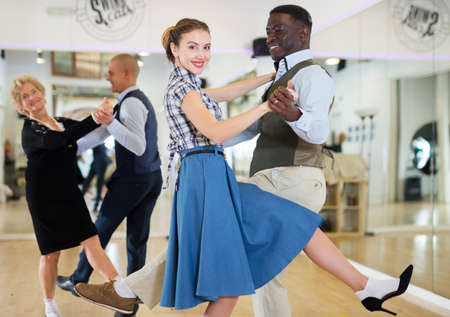 Woman with african man practising charleston dancingの写真素材