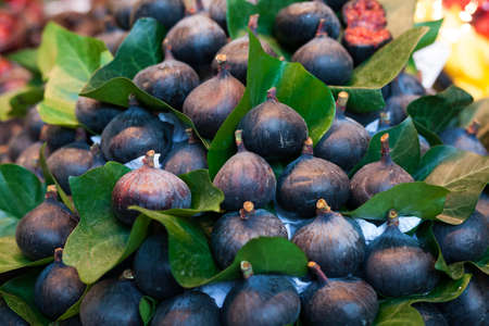 ripe figs with leaves on counter in market
