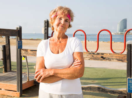 Old lady in outdoor workout station