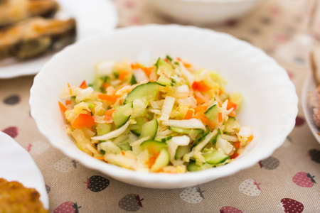 chopped cabbage, tomatoes, cucumbers, onions and herbs in a bowl