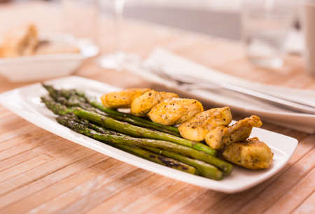 cooked dish. Chicken nuggets with green asparagus on plateの写真素材