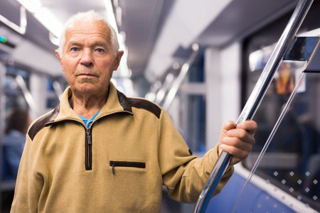 Old man standing in subway carの写真素材