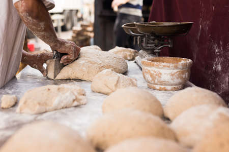 yeast dough in the form of loaves waiting to be cookedの写真素材