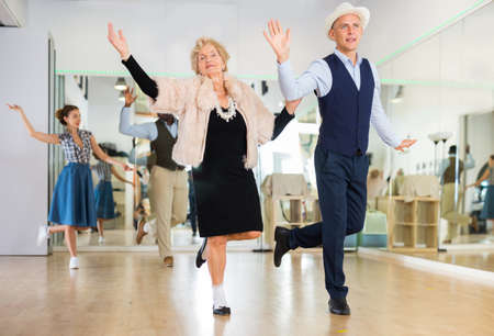 Mature woman dancing swing with young man