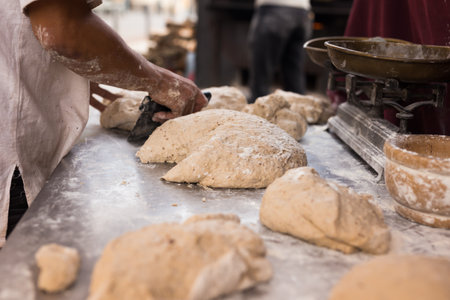 male hands knead yeast dough for baking breadの写真素材