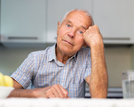 Portrait of an elderly lonely man at home in kitchenの写真素材