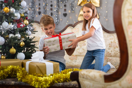 Brother and sister open boxes with giftsの写真素材