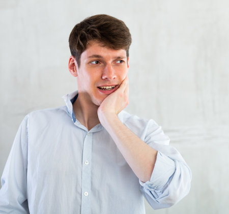 Unhappy man having a toothache in living room