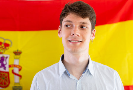 Portrait of positive student against background of flag of Spainの写真素材