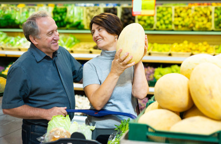 Elderly husband and wife choose high-quality melonの写真素材