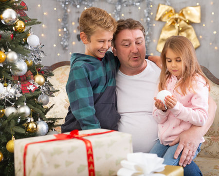 Dad with son and daughter on sofa in Christmas interiorの写真素材