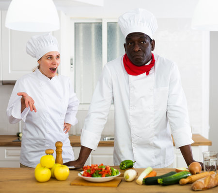 Chefs in white uniform having conflict on kitchenの写真素材