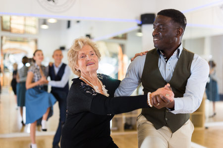 Woman pensioner with african man practising charlestonの写真素材