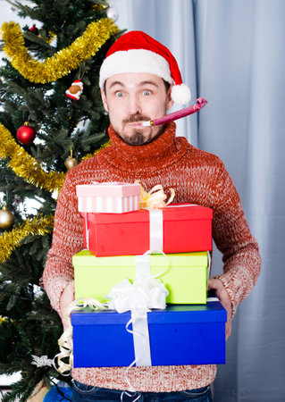Portrait of Man on holiday in hat and whistle with giftsの写真素材