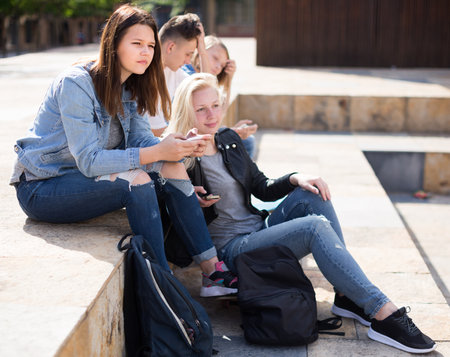 Teenagers communicate with each other in the schoolyardの写真素材