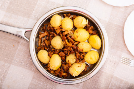 Delicious forest mushrooms chanterelles with young potatoes fried in frying pan. top viewの写真素材