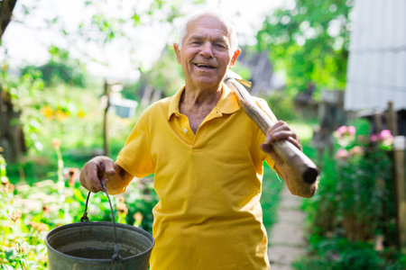 Man professional horticulturist with garden shovel working at landの写真素材