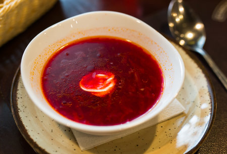 Beetroot soup with sour cream in bowl