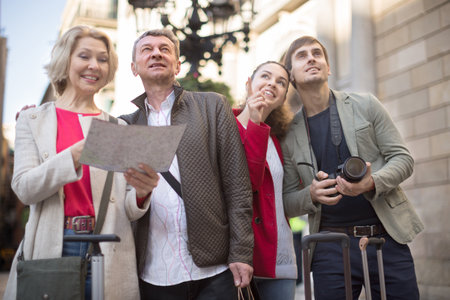 Couples of tourists look at a map and travel in a European cityの写真素材