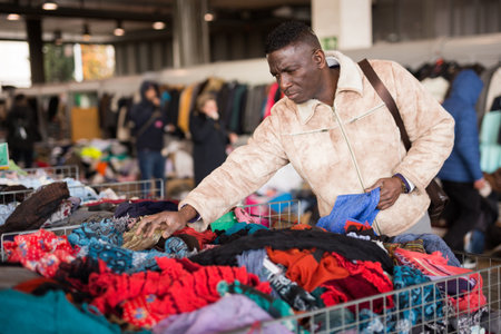 Man chooses used clothes at a flea marketの写真素材